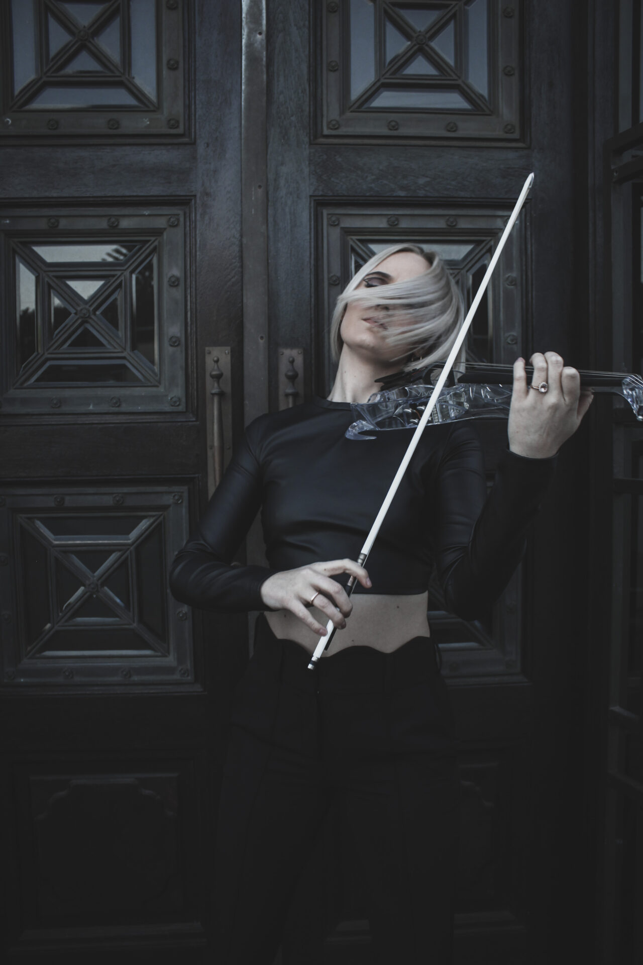 Donne Violinist playing in front of a wooden wine farm door in Stellenbosch